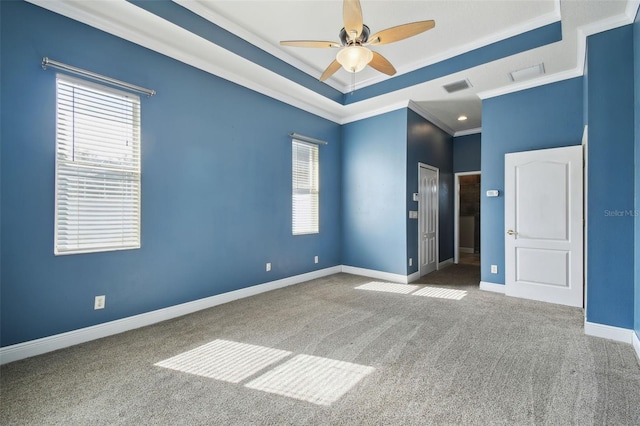 unfurnished room featuring ornamental molding, ceiling fan, a raised ceiling, and carpet flooring