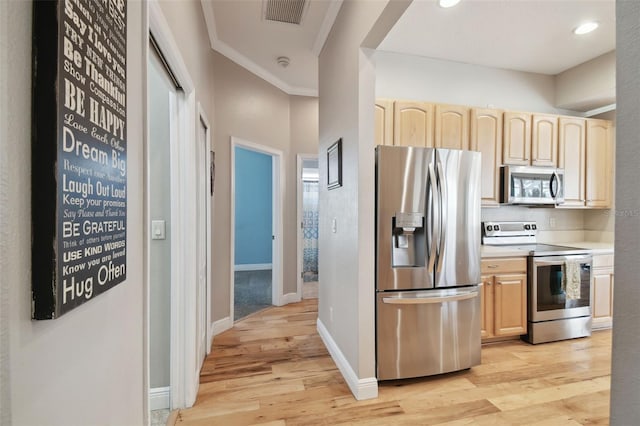 kitchen with stainless steel appliances, light brown cabinets, light wood-type flooring, and ornamental molding