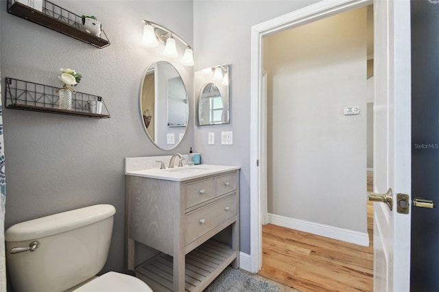 bathroom with hardwood / wood-style floors, vanity, and toilet