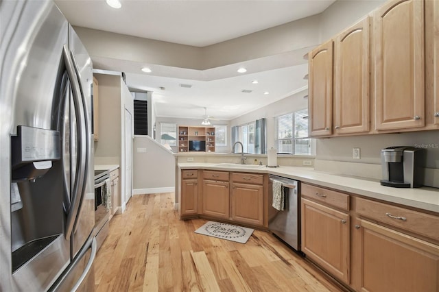 kitchen with kitchen peninsula, light hardwood / wood-style flooring, light brown cabinetry, appliances with stainless steel finishes, and sink