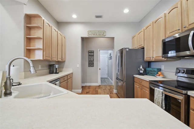 kitchen featuring sink, stainless steel appliances, light wood-type flooring, and light brown cabinetry