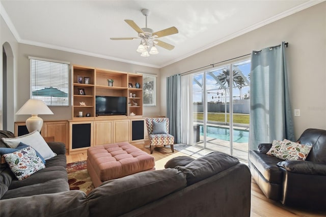 living room with light wood-type flooring, ceiling fan, and crown molding