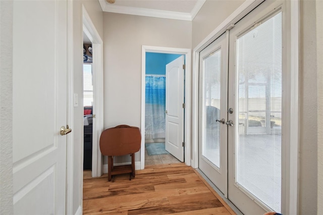 doorway to outside featuring ornamental molding, french doors, light hardwood / wood-style floors, and plenty of natural light