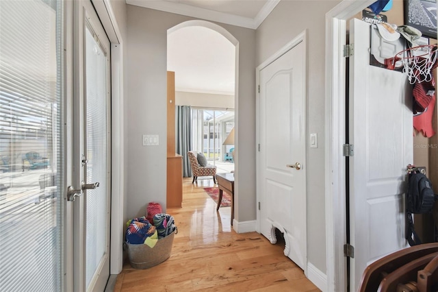 corridor featuring ornamental molding and light wood-type flooring