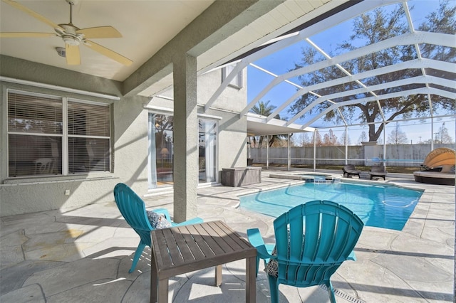 view of pool with ceiling fan, a patio area, glass enclosure, and an in ground hot tub