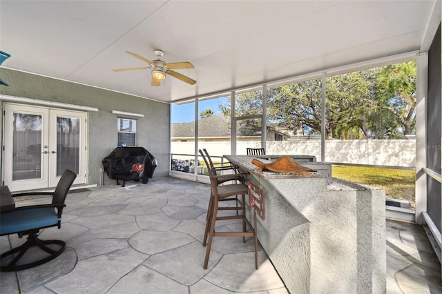 sunroom / solarium with ceiling fan and french doors