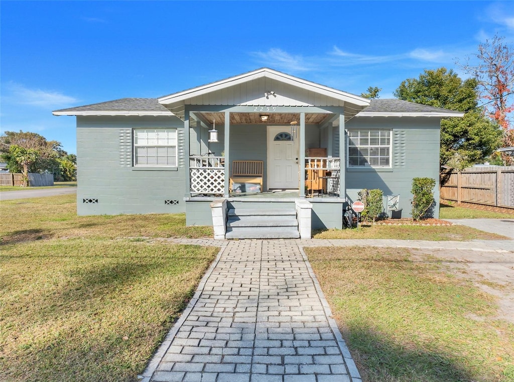 bungalow with a front yard and covered porch