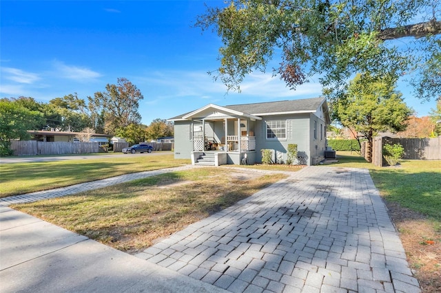 bungalow-style home featuring covered porch and a front lawn