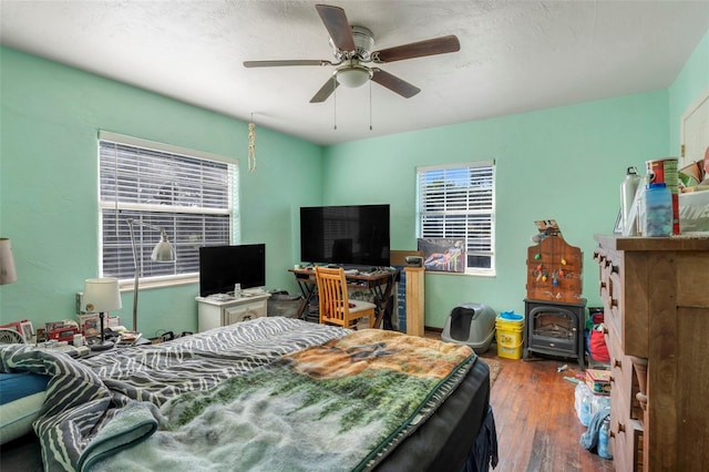 bedroom with ceiling fan, dark wood-type flooring, multiple windows, and a textured ceiling