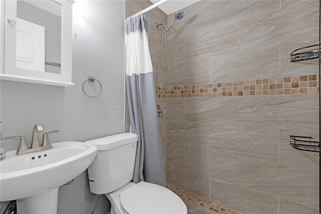 bathroom with toilet, a shower with curtain, and sink