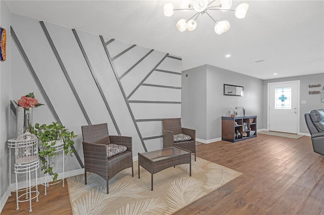 living area with wood-type flooring and a chandelier