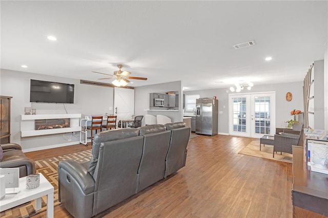 living room with ceiling fan, wood-type flooring, and french doors