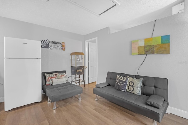 living room with a textured ceiling and wood-type flooring