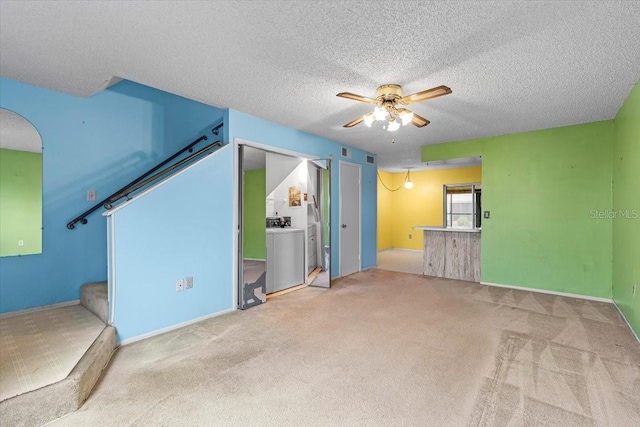 unfurnished living room with washer / clothes dryer, carpet floors, ceiling fan, and a textured ceiling