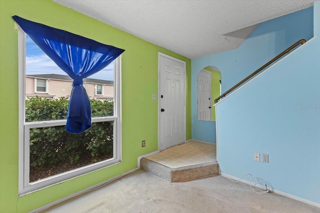 entrance foyer with carpet floors and a textured ceiling