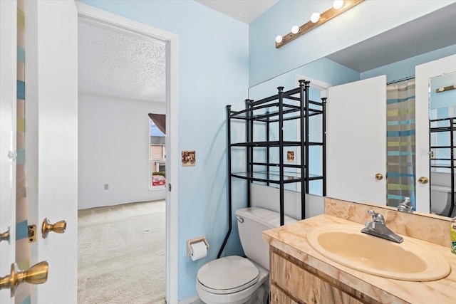 bathroom featuring a textured ceiling, vanity, and toilet