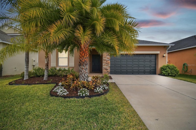 view of front of house with a garage and a yard