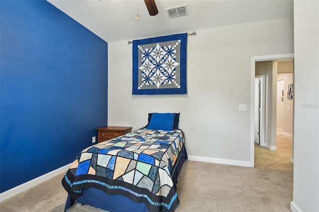 bedroom featuring a textured ceiling, ceiling fan, and carpet