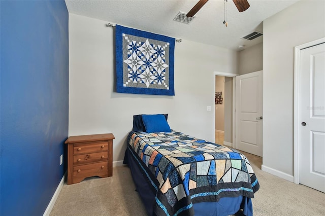 bedroom with a textured ceiling, ceiling fan, and carpet flooring