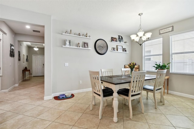 tiled dining area with a chandelier