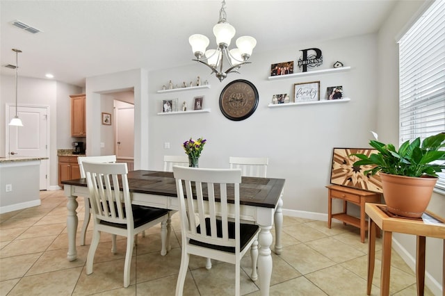 tiled dining space with a chandelier