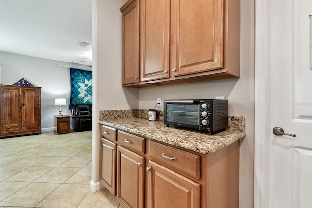 kitchen featuring light stone countertops and light tile patterned flooring