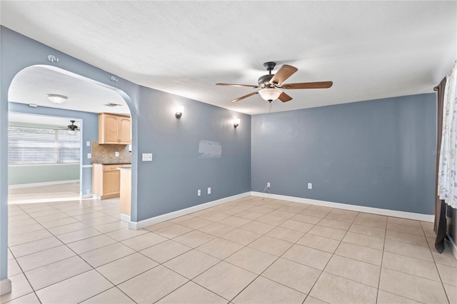 empty room with ceiling fan and light tile patterned floors