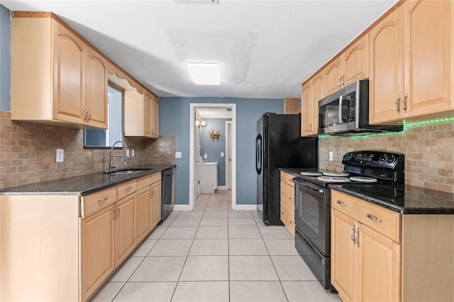 kitchen featuring sink, light tile patterned floors, black appliances, dark stone counters, and light brown cabinets