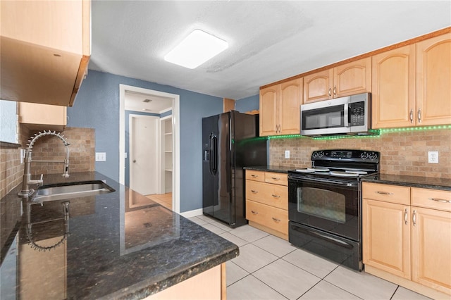 kitchen with light brown cabinetry, light tile patterned floors, black appliances, decorative backsplash, and sink