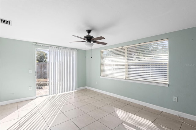 empty room with ceiling fan and light tile patterned floors