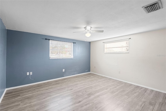 empty room featuring ceiling fan and light hardwood / wood-style flooring