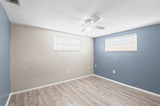 empty room featuring a textured ceiling, ceiling fan, and light wood-type flooring