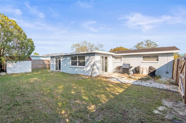 rear view of house with a yard and a storage shed