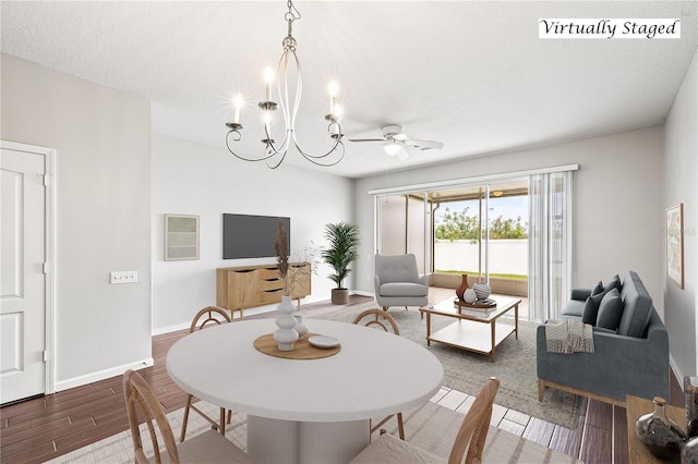 dining space with a textured ceiling and ceiling fan with notable chandelier