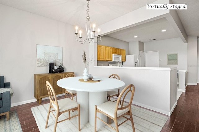 dining area featuring beamed ceiling and an inviting chandelier