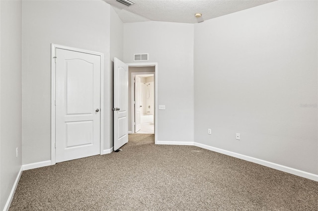 unfurnished bedroom featuring a high ceiling, carpet floors, and a textured ceiling