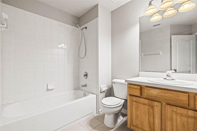 full bathroom with tile patterned flooring, vanity, tiled shower / bath combo, and toilet