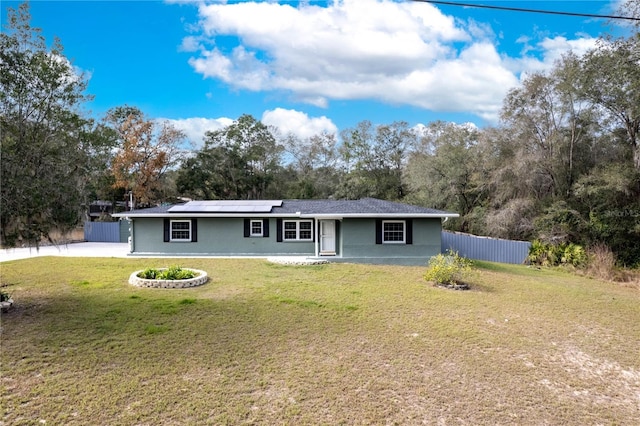 single story home with a front yard and solar panels