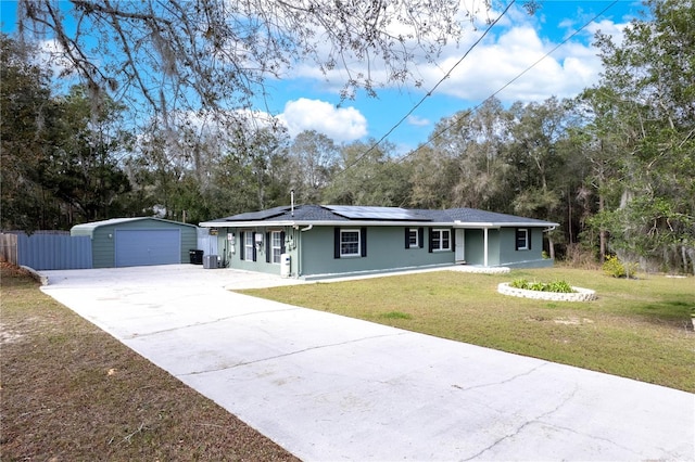 ranch-style house featuring a garage, a front lawn, and solar panels