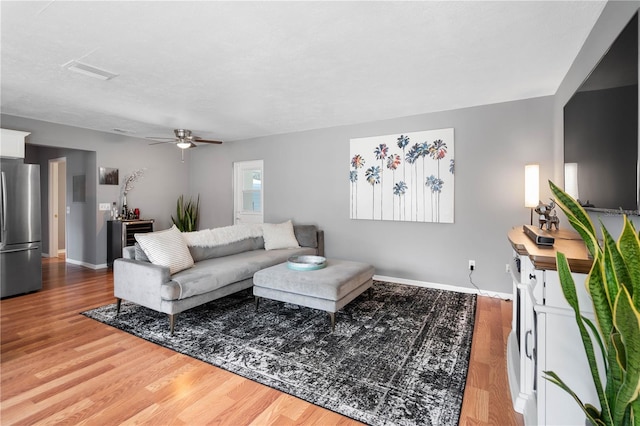 living room featuring ceiling fan and hardwood / wood-style floors