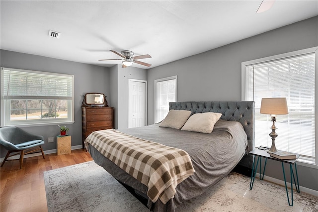 bedroom featuring ceiling fan, wood-type flooring, and a closet