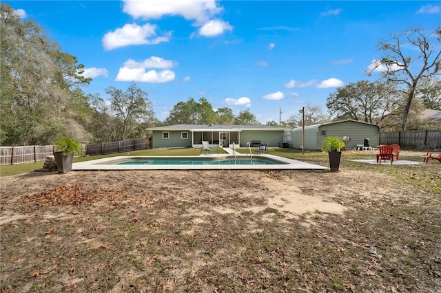 back of house with a fenced in pool and a patio area