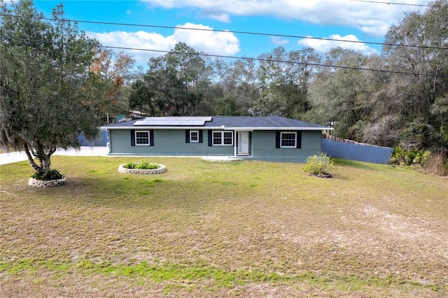 ranch-style home with a front lawn and solar panels