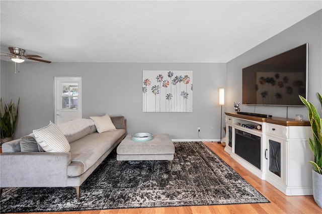 living room with ceiling fan and light wood-type flooring