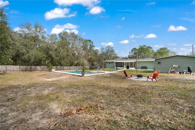 view of yard with an outdoor fire pit, a fenced in pool, and a patio