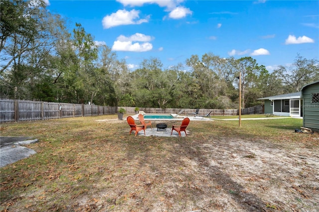 view of yard featuring an outdoor fire pit, a fenced in pool, and a sunroom