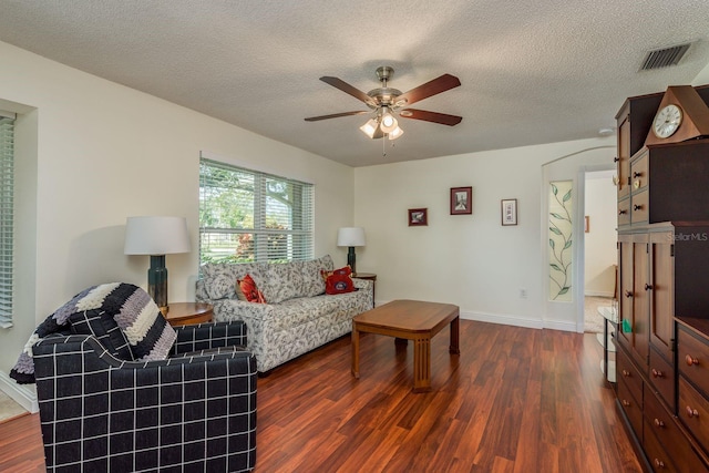 living room featuring a textured ceiling, ceiling fan, and dark hardwood / wood-style floors