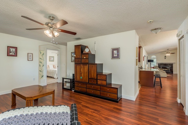 living room featuring ceiling fan and dark hardwood / wood-style floors