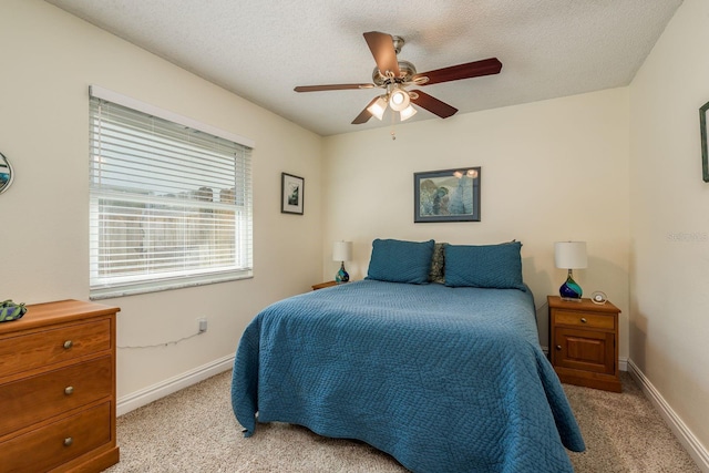 carpeted bedroom featuring a textured ceiling and ceiling fan