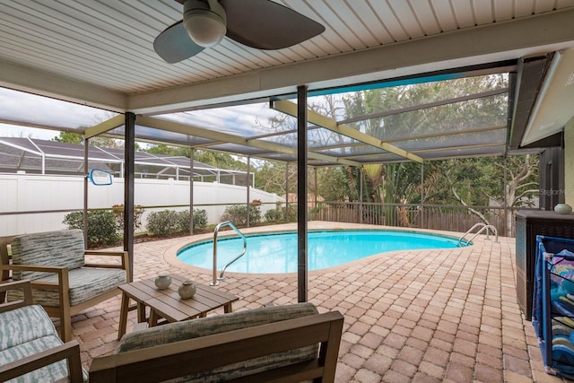 view of swimming pool featuring a patio area, ceiling fan, and glass enclosure